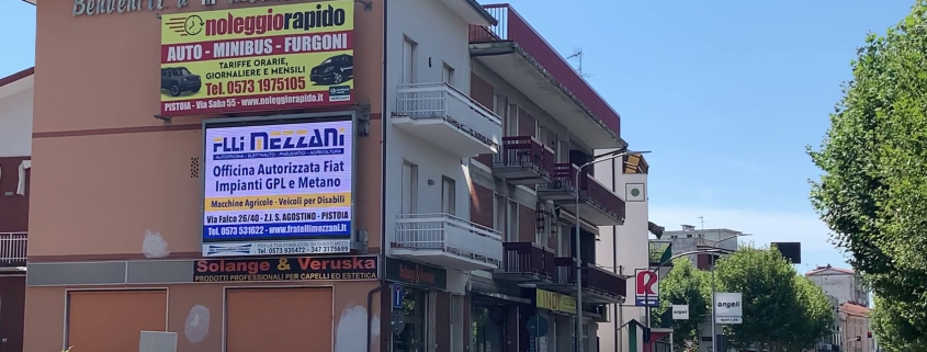 Maxi schermo LED pubblicitario installato su edificio a Montecatini Terme, utilizzato per promuovere attività commerciali locali come officine, autonoleggi e saloni di bellezza. Un esempio efficace di digital signage per aumentare la visibilità dei business locali in una zona ad alto traffico veicolare.